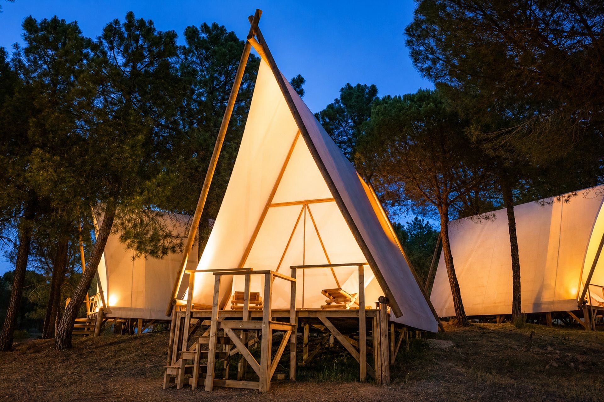 Alojamientos de Kampaoh Córdoba iluminados de noche entre pinos